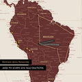 Detail einer Weltkarte in der Equal-Earth-Projektion als Pinn-Leinwand in der Farbe Bordeaux Rot, die eine abgesteckte Reiseroute in Südamerika durch die Länder Brasilien, Peru und Ecuador zeigt