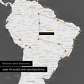 Dettaglio di una mappa del mondo come Mappa da puntine in grigio scuro con puntine che mostrano un itinerario di viaggio tracciato in Sud America attraverso i paesi Brasile, Perù ed Ecuador