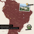 Dettaglio di una mappa del mondo magnetica come lavagna magnetica in rosso bordeaux che mostra il Sud America con una foto appuntata e magneti da viaggio e vacanza