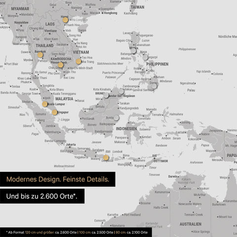 Dettaglio di una mappa magnetica del mondo in grigio chiaro che mostra la mappa dell'Asia, con magneti che indicano le destinazioni di viaggio