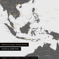 Dettaglio di una mappa magnetica del mondo in grigio chiaro che mostra la mappa dell'Asia, con magneti che indicano le destinazioni di viaggio